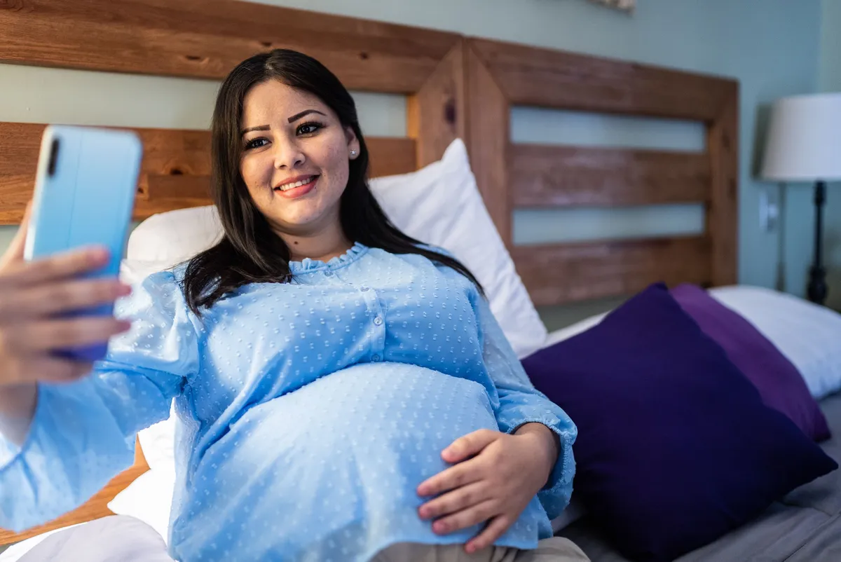 Pregnant woman holding phone on video call